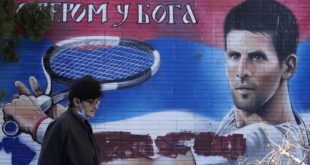 Žena kráča okolo nástennej maľby s podobizňou srbského tenistu Novaka Djokoviča v Belehrade